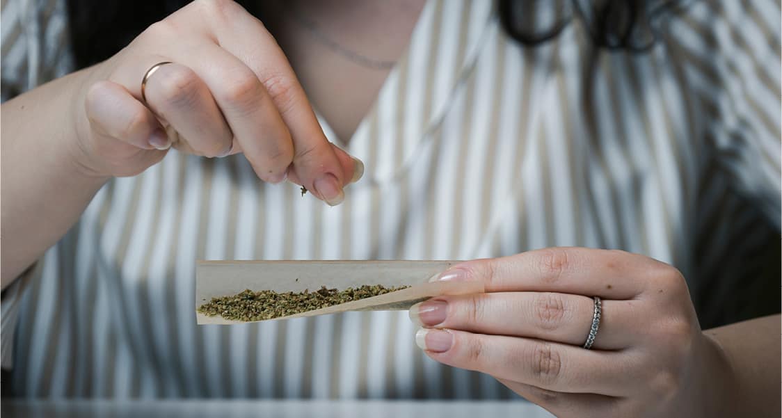 filling rolling paper with cannabis flower